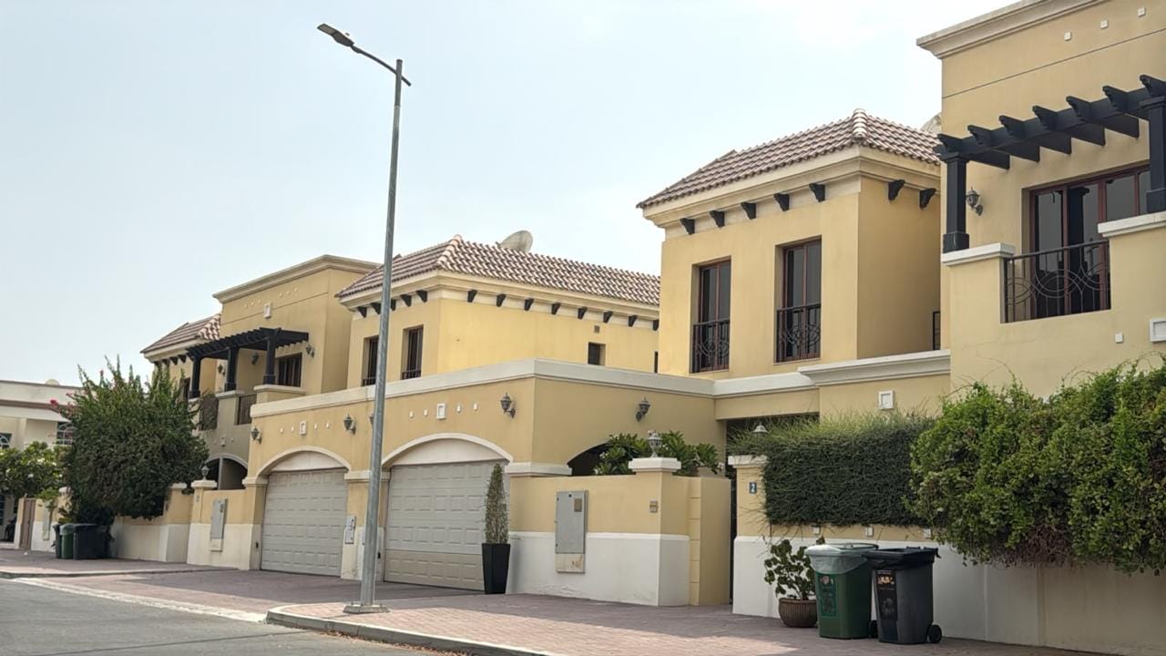 Yellow Mediterranean-style villas with landscaped boundary hedges in Jumeirah, Dubai