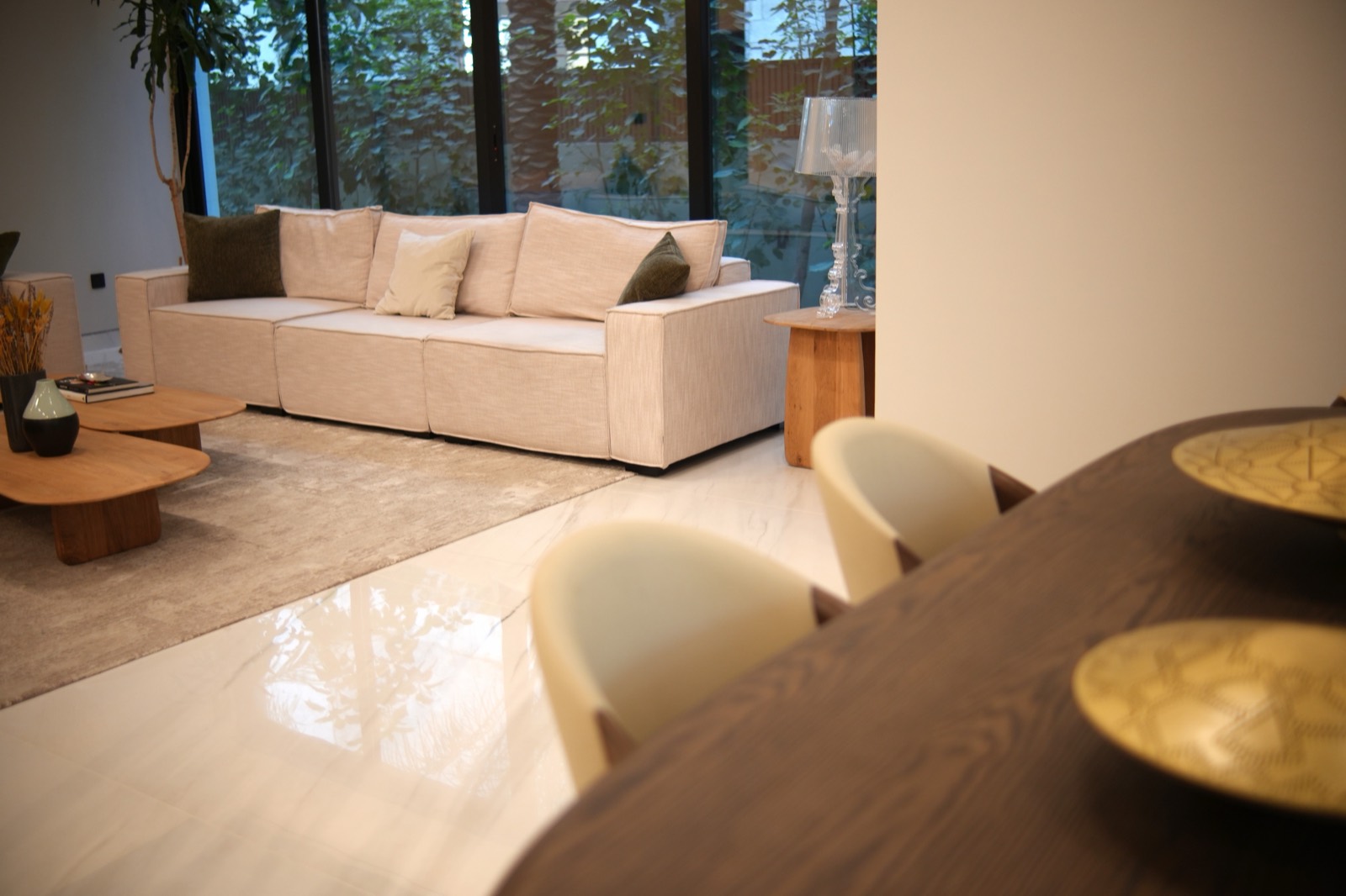 Warm minimalist living and dining room with full-height glazing in a NovaPlex Dubai interior